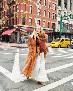 a woman is crossing the street while talking on her cell phone