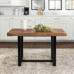 a kitchen with white cabinets and black metal legs on an area rug in front of the counter