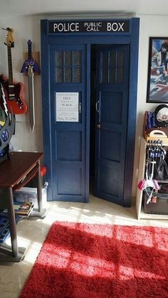 a room with a blue police box on the wall and a red rug in front of it