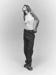 black and white photograph of a woman standing with her hands on her hips, looking to the side