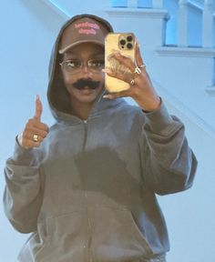 a man with a fake moustache on taking a selfie in front of stairs