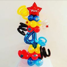 balloons are stacked on top of each other to spell out the number four in front of them