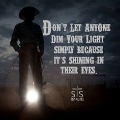 a man with a cowboy hat and lasso standing in front of a dark sky