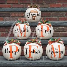 pumpkins with names painted on them sitting in front of a brick wall and steps