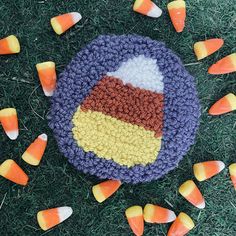 a crocheted cake with candy corn on the side and candies scattered around it