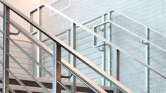 a metal hand rail on the side of a stair case in an office building with glass balconies