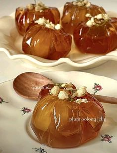 there are four small pumpkins on the plate with spoons in front of them