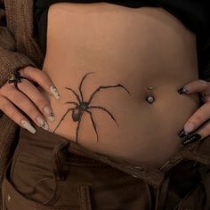 a woman's stomach with a spider tattoo on it