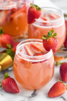 a strawberry and lime garnish in a wine glass on a marble countertop