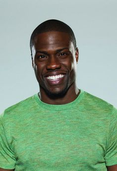 a man in a green shirt smiling at the camera