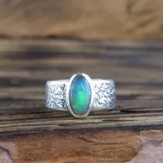 An Ethiopian Welo Opal gemstone set in a .999 fine silver ring. US Ring Size 6 1/4 Opal weight: 1.35ct Ring weighs 12.5g including stone. Opal including setting measures 11mm by 7mm Ring band width: 8mm All metal parts are handmade using .999 fine silver All cabochons are cut and polished by myself. Handmade by Mike Summers. Looking after your opal... Ethiopian opals are hydrophane opals, which mean they absorb water. They can temporarily lose color if they get wet, but the color will start to return. It's usually best to avoid wearing if swimming, or where it will be submersed in water. Your opal can be washed in water and then dried with a soft cloth. Do not use chemical cleaners or ultrasonic cleaners and keep them free from oils, perfumes and lotions. We are husband and wife Mike and A Artisan Sterling Silver Oval Opal Ring, Artisan Oval Opal Ring In Sterling Silver, Oval Sterling Silver Opal Ring With Stone Setting, Opal Silver Ring, Metal Jewellery, Welo Opal, Ring Band, Opal Jewelry, Opal Gemstone