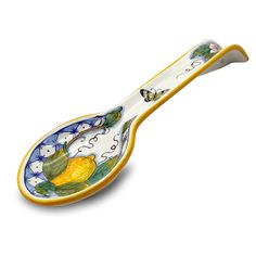 a yellow and white spoon with an image of lemons on the side, sitting in front of a white background