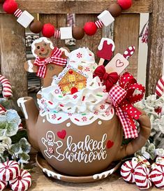 a teapot with some decorations on top of it and candy canes around it