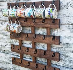 a coffee cup holder is mounted on a wall with several cups hanging from it's hooks