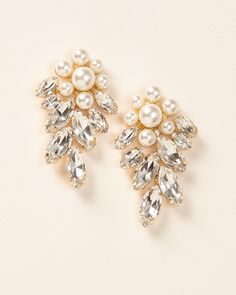 Head turning, bold & floral, our Verona Earrings are the perfect way to make a statement. Add a touch of sophistication and sparkle when you wear these earrings for weddings, black tie events or even your next girls night out. Details: Multiple sized, light ivory pearls look like a flower. Top grade rhinestones for high shine (day or night). Specifications: 2" in length x 1.25" wide. Earrings are slightly heavier than some, but worth it! Tarnish Resistant: Earrings are tarnish resistant for long Elegant Crystal Flower Earrings For Party, Elegant Flower Earrings With Sparkling Stones For Wedding, Elegant Formal Crystal Pearl Earrings, Elegant Wedding Flower Earrings With Sparkling Stones, Elegant Clip-on Dangle Flower Earrings, Formal Drop Cluster Earrings With Sparkling Stones, Elegant Pearl Earrings With Sparkling Stones For Party, Elegant Crystal Pearl Earrings For Pierced Ears, Elegant Crystal Cluster Earrings For Anniversary