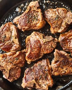 steaks are cooking in a skillet on the stove