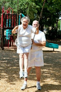 an older couple swinging on a swing set