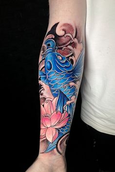 a person with a blue bird tattoo on their arm and leg, next to a pink flower