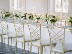 a long table with white flowers and candles is set for a formal dinner or reception