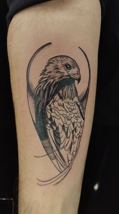 an eagle tattoo on the leg of a man's arm, it is black and white