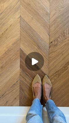 a person standing on top of a wooden floor next to a white wall and wood floors