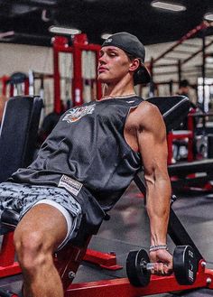 a man sitting on top of a bench in a gym