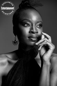 a black and white photo of a woman with her hand on her chin, looking at the camera