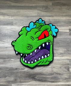 a rug with a green dragon head on it's side and red eyes in the center