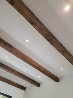 a room with white walls and wooden beams