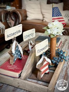 an american flag centerpiece on a tray with other patriotic items and flowers in it