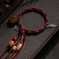 a close up of a bracelet with beads and charms on top of a leather case