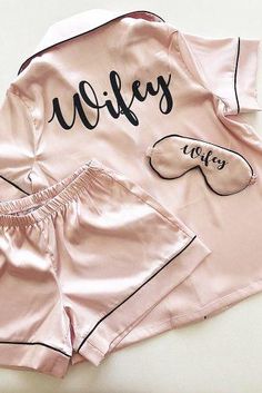 two pieces of pink satin pajamas with matching sleep masks on the front and bottom, along with one pair of eyeglasses