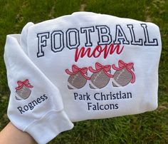 This cute and comfy sweatshirt is perfect for sports Moms. Available in various sizes, two styles (crewneck and hoodie) and multiple colors. Option to customize the sleeve with child's name and/or jersey number.  "FOOTBALL mom" will be embroidered in the trendy arched font, with a cute and trendy coquette bow trio of balls embroidered below. You may also customize with text of your choice below the balls.  Also includes a name or text of your choice along with a ball embroidered on the sleeve ne White Letter Embroidered Sweatshirt For Sports Events, White Sweatshirt With Letter Embroidery For Sports Events, White Sweatshirt With Custom Embroidery For Sports, White Custom Embroidery Sweatshirt For Sports, White Sweatshirt With Embroidered Sports Graphics, White Sweatshirt With Embroidered Graphics For Sports, White Embroidered Sweatshirt For Sports Season, White Sporty Hoodie With Custom Embroidery, White Sporty Hoodie With Embroidered Text