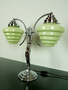 a green table lamp sitting on top of a black counter