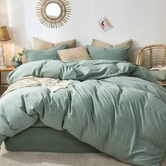 a bed with green comforter and pillows in a bedroom