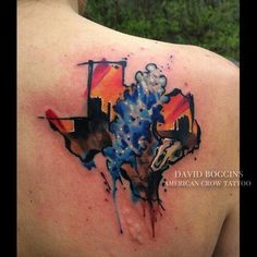 the back of a woman's shoulder with watercolor paint splashing on it