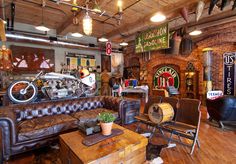 an old fashioned motorcycle shop with leather furniture and decorations on the walls, along with wooden floors