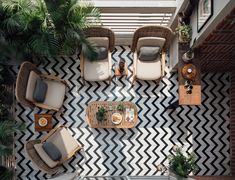 an overhead view of a patio with chairs, tables and potted plants on it