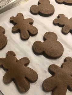 some cookies shaped like mickey mouses are on a cookie sheet and ready to be baked