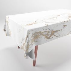 a white and gold table cloth with wooden legs