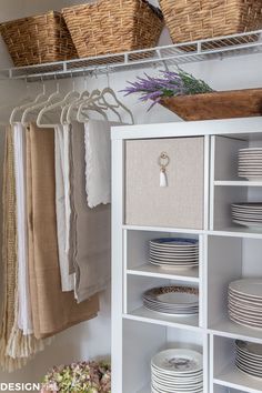 a white cabinet filled with dishes and plates next to wicker baskets on the wall