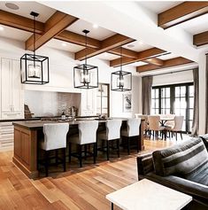 a living room filled with furniture next to a kitchen