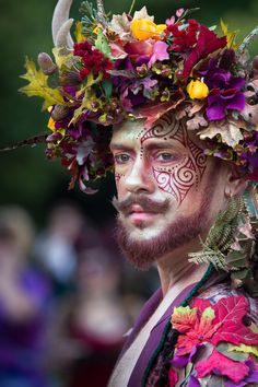 a man with flowers on his head and face