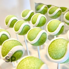 there are many green and white lollipops on the stick in front of each other