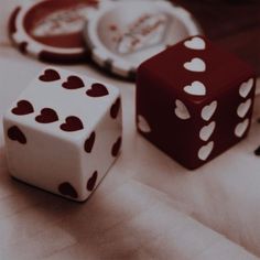 two dices sitting next to each other on top of a white cloth covered table