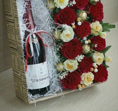 a bottle of wine and some flowers in a box