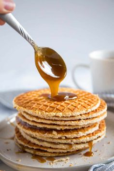 a stack of pancakes with syrup being drizzled on top