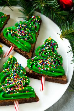 christmas tree shaped cookies on a plate with candy canes