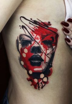 a woman's stomach with the face of a clown painted in red and black