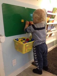 a little boy playing with legos on the wall